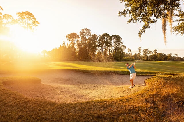 Man playing golf while on family vacation in Orlando Florida.