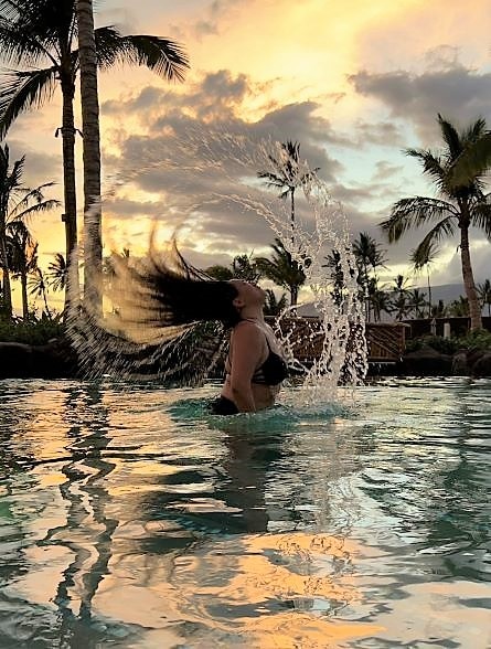 Hilton Grand Vacations Owner frolicking in pool, sunset skies, Maui Bay Villas, a Hilton Grand Vacations Club, Hawaii.