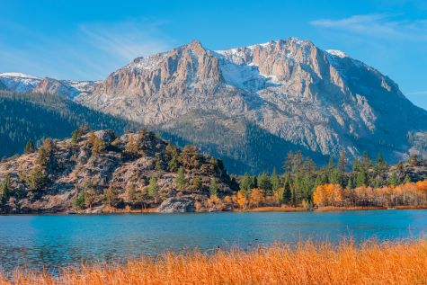Gorgeous mountain scene, fall foliage framing lake, mountains in distance, Donner Lake, California.